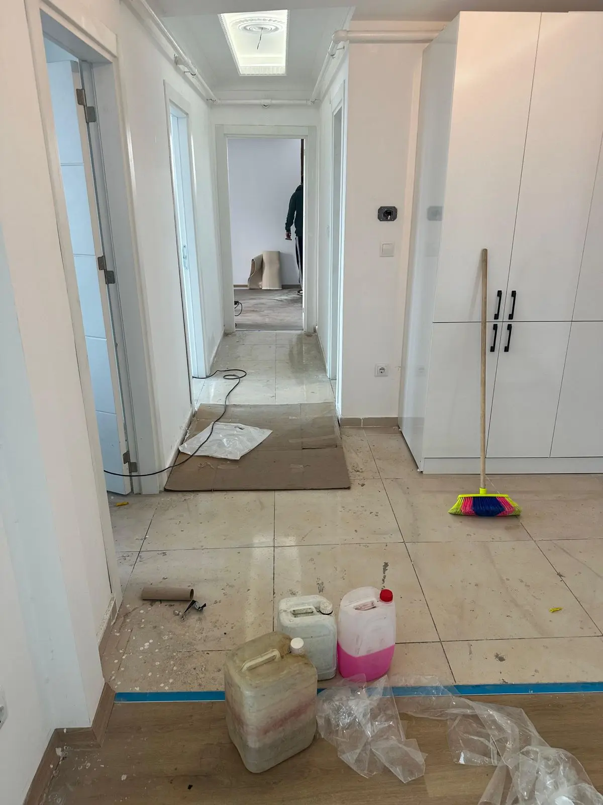 Ev temizliği öncesinde zeminde toz ve kullanım izleri bulunan antre ve koridor alanı