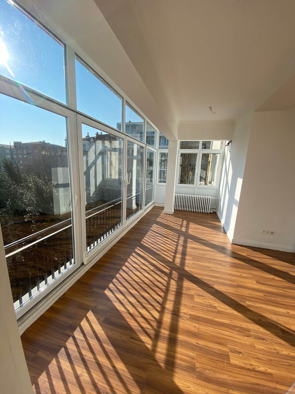 Aynı kapalı balkon uygulama sonrası: cam cephe temizlenmiş, yüzeyler yenilenmiş, parke zemin
