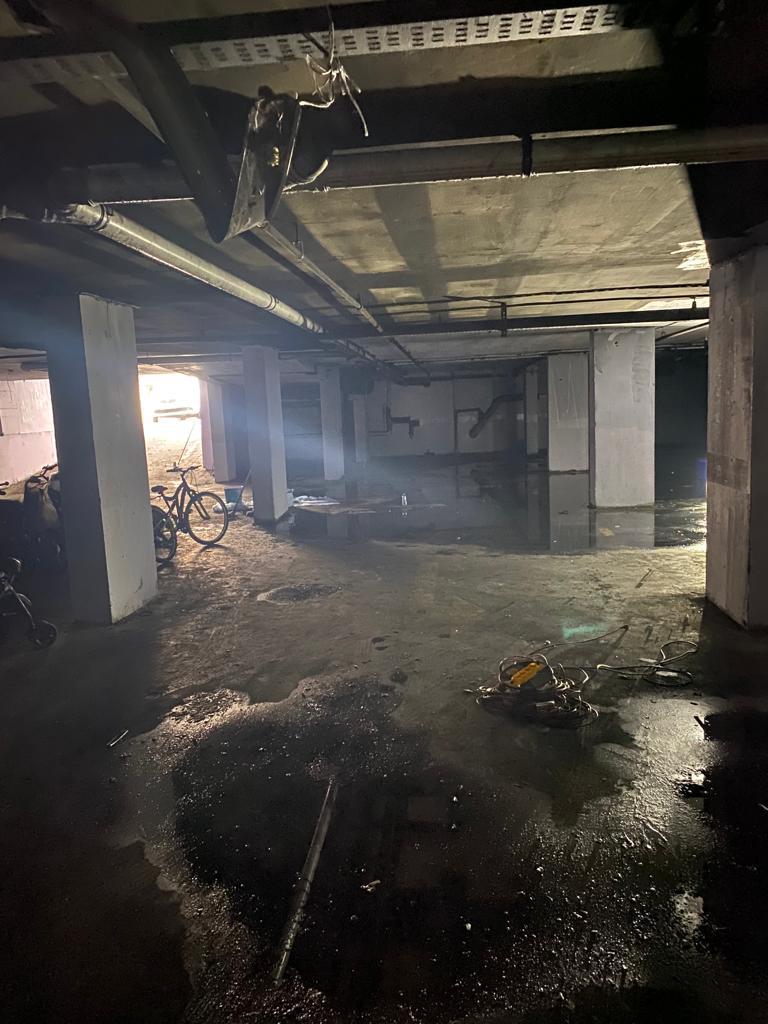 Yangın sonrası kapalı otopark: tavan ve kolonlar kararmış, zeminde moloz ve atık
